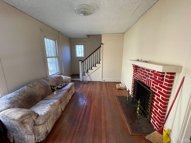 1706 Floyd St, Lynchburg, VA 24501 - living area with a textured ceiling, hardwood / wood-style flooring, a brick fireplace, stairs, and baseboards