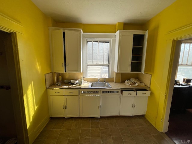 1706 Floyd St, Lynchburg, VA 24501 - kitchen with a sink, open shelves, white cabinetry, and dark tile patterned floors
