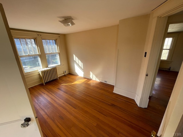 1706 Floyd St, Lynchburg, VA 24501 - empty room with radiator, wood finished floors, healthy amount of natural light, and baseboards