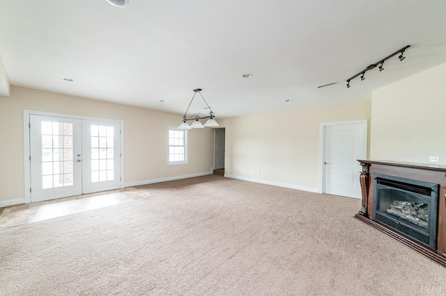 126 Golf Course Trl, Amherst, VA 24521 - unfurnished living room featuring baseboards, a glass covered fireplace, carpet flooring, and rail lighting