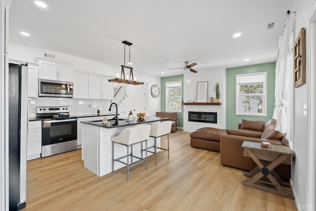 71 Patrick Ct, Madison Heights, VA 24572 - kitchen with stainless steel appliances, a sink, a breakfast bar area, a fireplace, and open floor plan