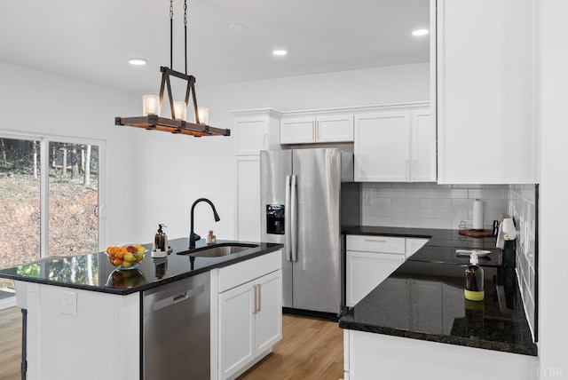 71 Patrick Ct, Madison Heights, VA 24572 - kitchen with appliances with stainless steel finishes, a sink, light wood finished floors, tasteful backsplash, and white cabinets