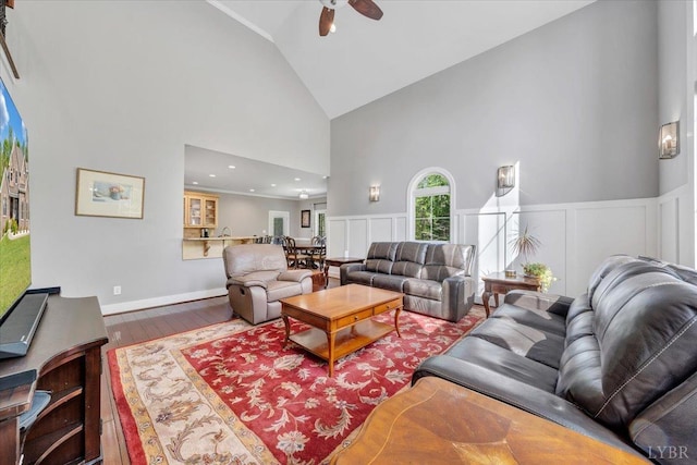 1037 Deer Hollow Rd, Forest, VA 24551 - living room featuring high vaulted ceiling, wood finished floors, ceiling fan, a wainscoted wall, and a decorative wall