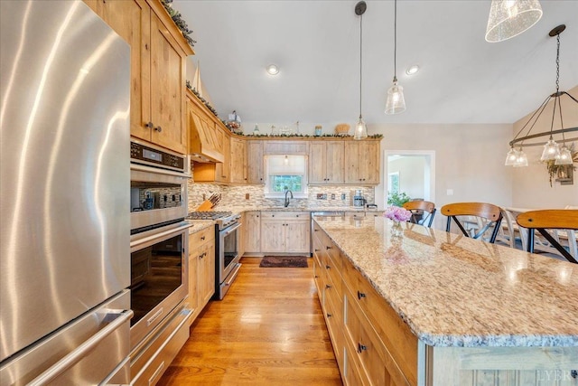 20438 Wyatts Way, Evington, VA 24550 - kitchen featuring appliances with stainless steel finishes, a warming drawer, a center island, decorative backsplash, and light wood finished floors