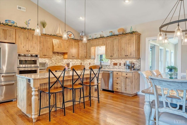 20438 Wyatts Way, Evington, VA 24550 - kitchen with stainless steel appliances, decorative backsplash, vaulted ceiling, light stone counters, and a kitchen bar