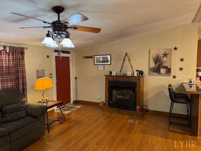 3164 Trent Hatchery Rd, Appomattox, VA 24522 - living room featuring a ceiling fan, wood finished floors, a fireplace with raised hearth, and baseboards