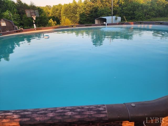 3164 Trent Hatchery Rd, Appomattox, VA 24522 - swimming pool featuring an outbuilding, a view of trees, and a shed