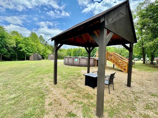 3164 Trent Hatchery Rd, Appomattox, VA 24522 - view of grassy yard featuring a storage shed, stairway, an outbuilding, a gazebo, and an outdoor fire pit