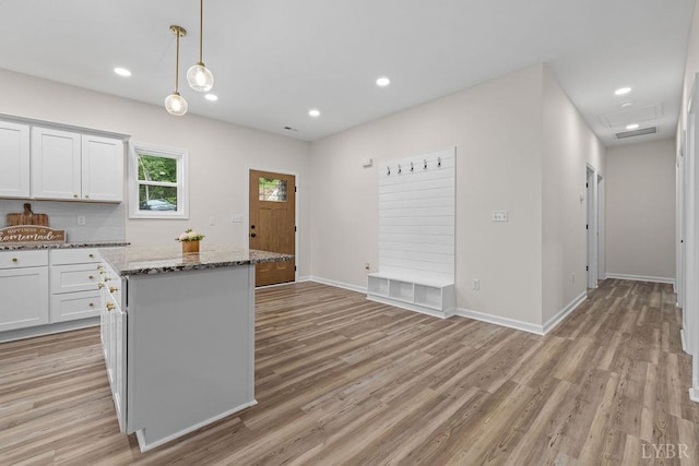 2127 Elm St, Lynchburg, VA 24504 - kitchen with light wood-style floors, white cabinets, a kitchen island, stone countertops, and decorative light fixtures