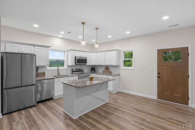 2127 Elm St, Lynchburg, VA 24504 - kitchen featuring appliances with stainless steel finishes, a sink, backsplash, wood finished floors, and healthy amount of natural light