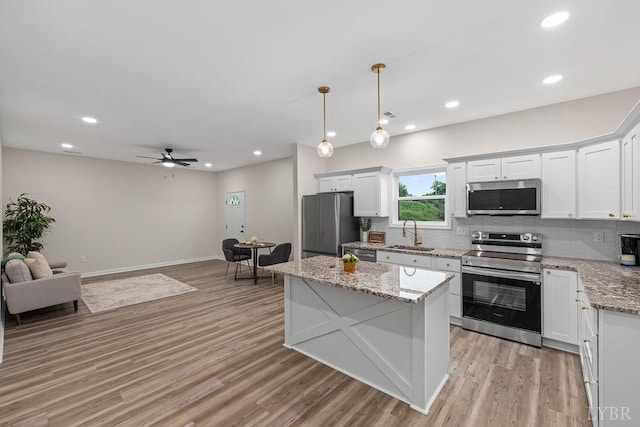 2127 Elm St, Lynchburg, VA 24504 - kitchen with stainless steel appliances, a sink, tasteful backsplash, light wood-style floors, and white cabinets