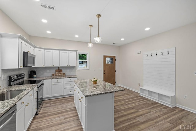 2127 Elm St, Lynchburg, VA 24504 - kitchen with stainless steel appliances, light wood finished floors, white cabinetry, a kitchen island, and pendant lighting