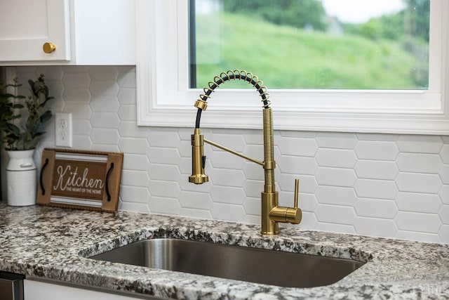 2127 Elm St, Lynchburg, VA 24504 - kitchen view of a sink, stone countertops, white cabinets, and backsplash