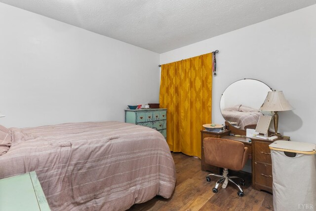 bedroom featuring wood finished floors and a textured ceiling