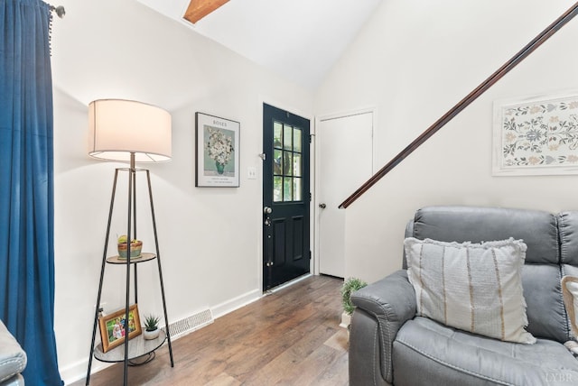 entrance foyer with vaulted ceiling, wood finished floors, and baseboards