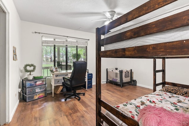 bedroom featuring wood finished floors, a desk, and baseboards