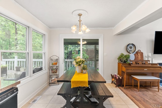 dining space with a chandelier, plenty of natural light, light tile patterned flooring, and crown molding