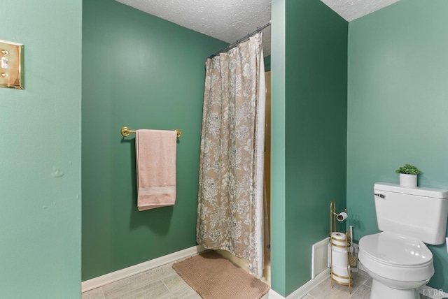 bathroom featuring a textured ceiling, toilet, baseboards, a shower with shower curtain, and wood finished floors