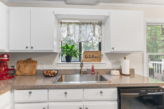 kitchen with dishwasher, a sink, and white cabinets