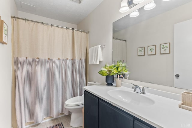 bathroom featuring toilet, vanity, and a textured ceiling