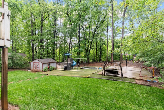 view of grassy yard featuring a playground, a storage unit, and an outdoor structure