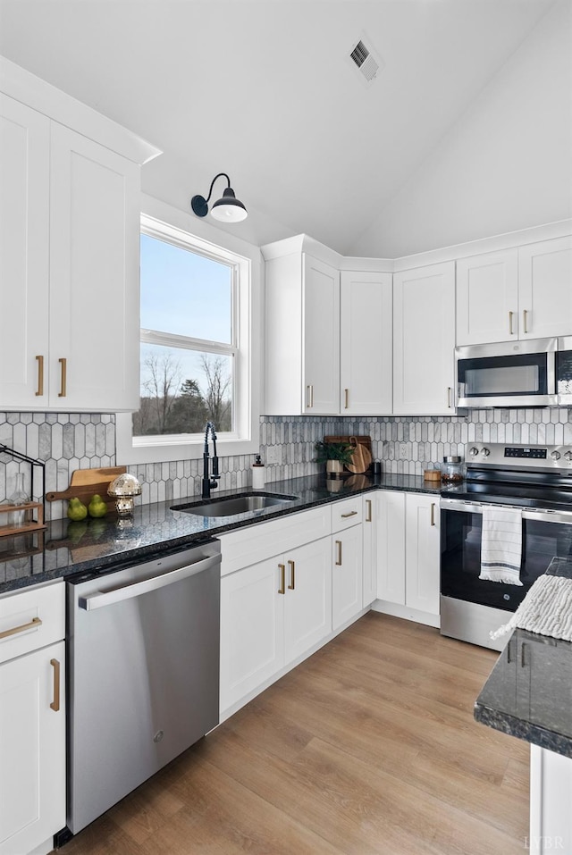 133 Fox Hall Dr, Amherst, VA 24521 - kitchen featuring stainless steel appliances, a sink, lofted ceiling, backsplash, and white cabinetry