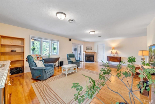 806 Cedar Key Ln, Huddleston, VA 24104 - living area featuring a fireplace with flush hearth, light wood-style flooring, and a textured ceiling
