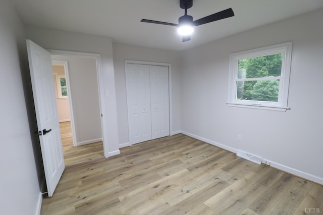 295 Charles Dr, Appomattox, VA 24522 - unfurnished bedroom with multiple windows, light wood finished floors, and a closet