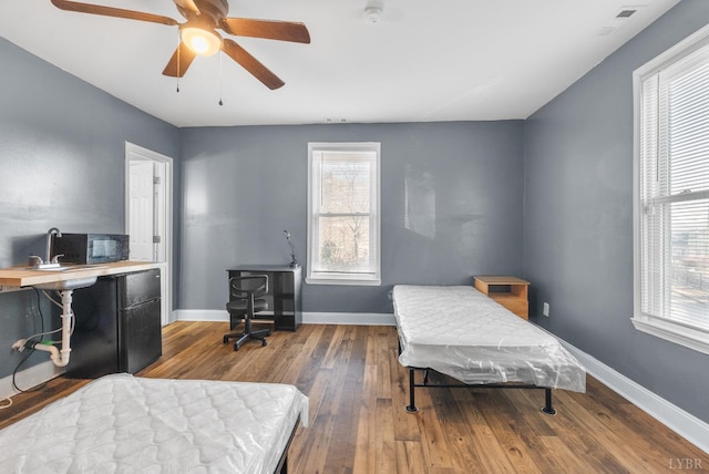 915 17th St, Lynchburg, VA 24504 - bedroom featuring wood finished floors, multiple windows, baseboards, and a ceiling fan
