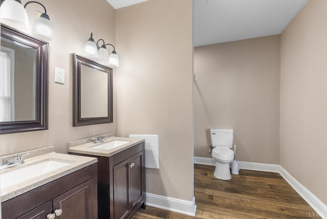 915 17th St, Lynchburg, VA 24504 - bathroom featuring wood finished floors, toilet, baseboards, and two vanities