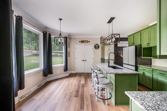 135 Warner Rd, Lynchburg, VA 24504 - kitchen featuring a sink, green cabinets, a chandelier, crown molding, and light wood-style floors