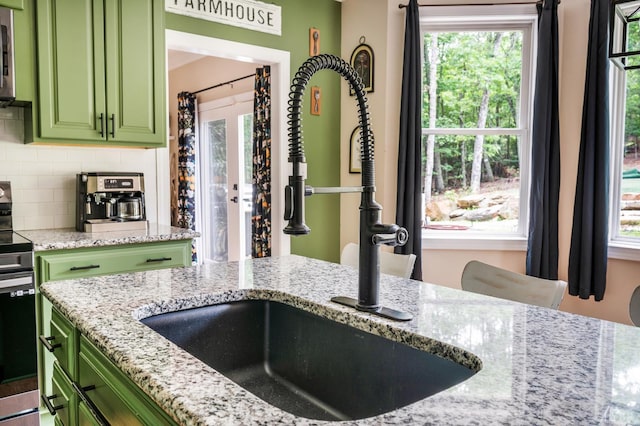 135 Warner Rd, Lynchburg, VA 24504 - kitchen with green cabinetry, a sink, electric stove, light stone counters, and backsplash
