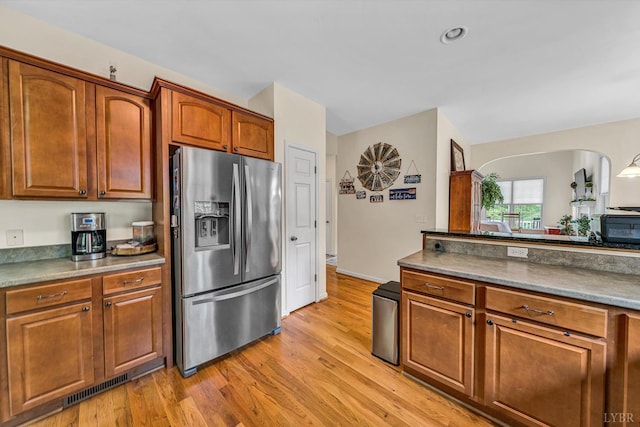 1309 W Pine Ridge Rd, Huddleston, VA 24014 - kitchen featuring stainless steel fridge, light wood-style flooring, brown cabinets, and arched walkways
