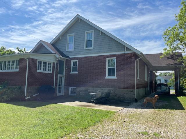 202 Leftwich St, Gretna, VA 24557 - rear view of property featuring brick siding, a yard, and an attached carport