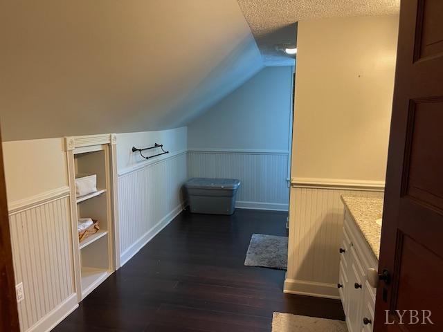 202 Leftwich St, Gretna, VA 24557 - bonus room featuring wainscoting, dark wood-style floors, and vaulted ceiling