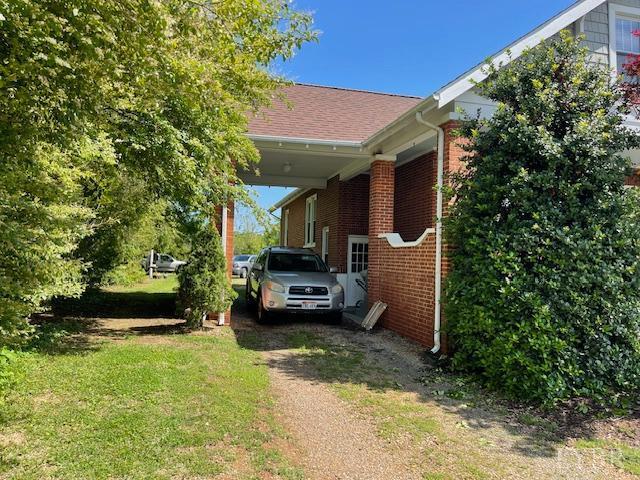 202 Leftwich St, Gretna, VA 24557 - view of side of home featuring brick siding, an attached carport, and driveway