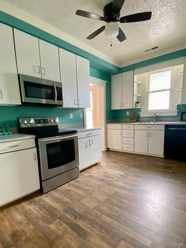 802 Erskine Ave, Lynchburg, VA 24501 - kitchen featuring appliances with stainless steel finishes, a textured ceiling, wood finished floors, white cabinetry, and a ceiling fan