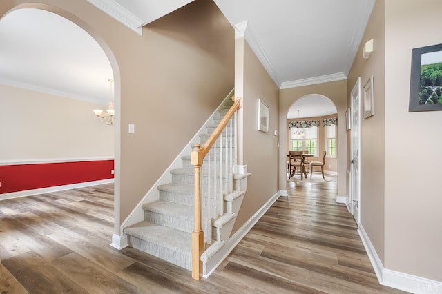 3374 Goode Station Rd, Goode, VA 24556 - staircase featuring arched walkways, wood finished floors, crown molding, baseboards, and a chandelier