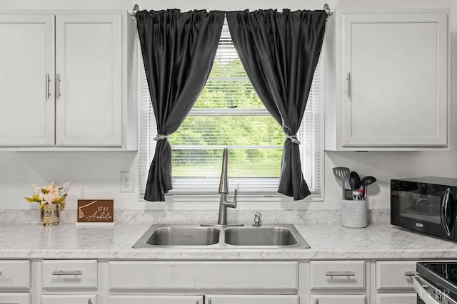 702 11th St, Altavista, VA 24517 - kitchen with a sink, black microwave, and white cabinets