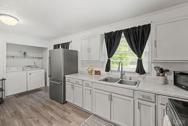 702 11th St, Altavista, VA 24517 - kitchen featuring separate washer and dryer, a sink, freestanding refrigerator, black microwave, and stove