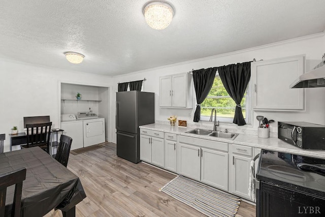702 11th St, Altavista, VA 24517 - kitchen featuring black appliances, separate washer and dryer, a sink, a textured ceiling, and light countertops