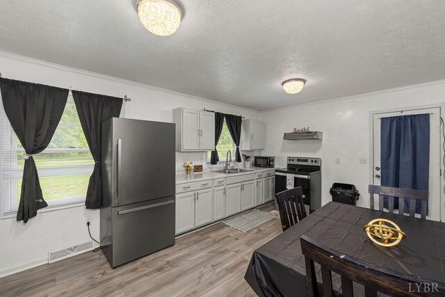 702 11th St, Altavista, VA 24517 - kitchen featuring stainless steel appliances, a sink, a textured ceiling, light countertops, and light wood-style flooring