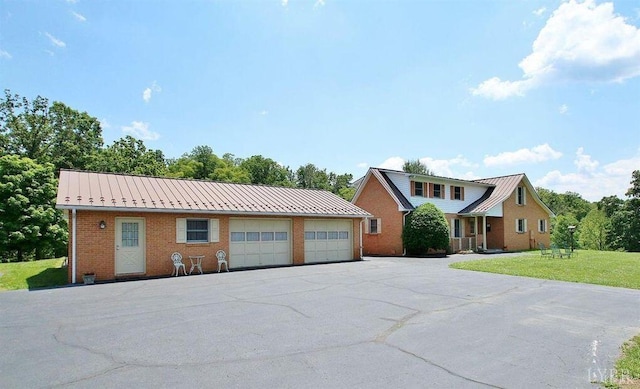 450 Holyfield Ln, Moneta, VA 24121 - view of front of house featuring brick siding, a metal roof, a front lawn, and a detached garage