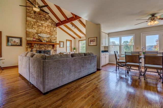 450 Holyfield Ln, Moneta, VA 24121 - living room with ceiling fan, a fireplace, beamed ceiling, wood finished floors, and high vaulted ceiling