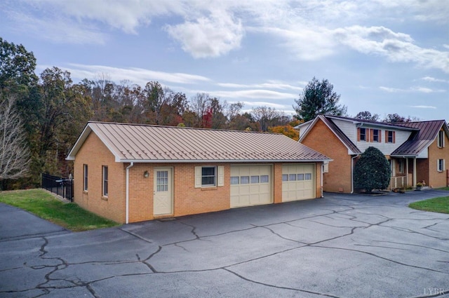 450 Holyfield Ln, Moneta, VA 24121 - view of front of house with brick siding, a detached garage, a standing seam roof, and a metal roof