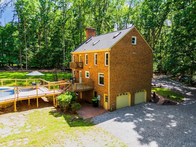 134 Woodmont Ln, Forest, VA 24551 - view of side of property featuring a garage, a chimney, brick siding, and a wooden deck