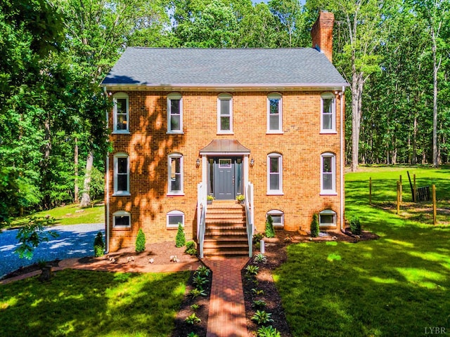 134 Woodmont Ln, Forest, VA 24551 - colonial house with a chimney, a shingled roof, and brick siding