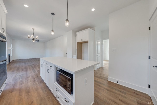 1197 Elk Creek Rd, Forest, VA 24551 - kitchen featuring black microwave, a chandelier, wood finished floors, white cabinets, and a kitchen island
