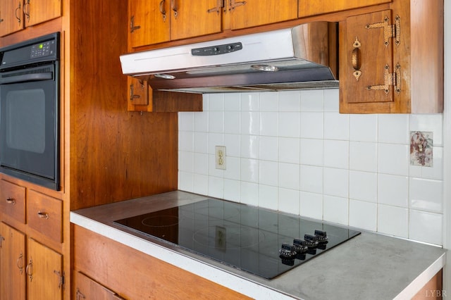 5822 Apache Ln, Lynchburg, VA 24503 - kitchen with black appliances, under cabinet range hood, decorative backsplash, and brown cabinetry