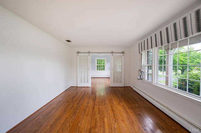 5822 Apache Ln, Lynchburg, VA 24503 - empty room featuring baseboard heating, wood finished floors, baseboards, and a barn door